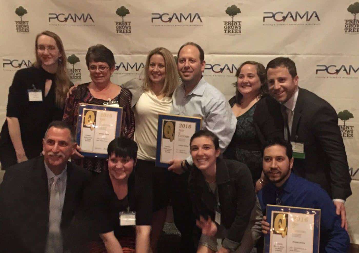 Strategic Factory president and CEO, Keith Miller, holding up an award plaque with a group of winners at the PGMA gala