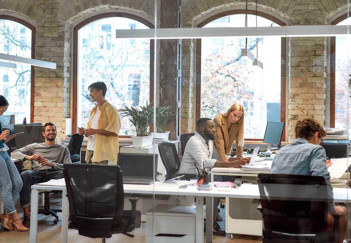 people working in an office space with glass walls