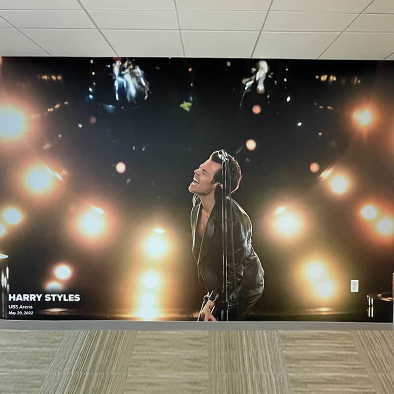 Floor to ceiling wall graphic of Harry Styles installed at the CFG Bank Arena