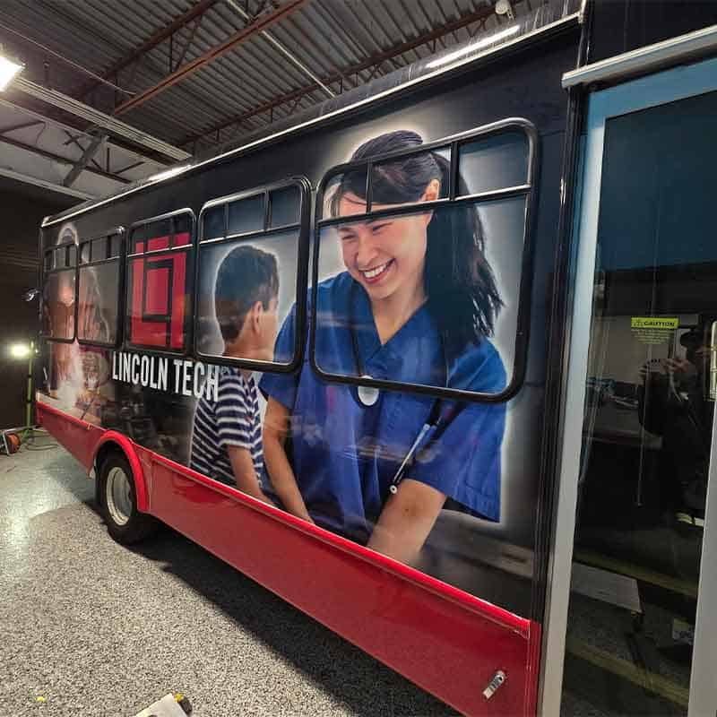 Vehicle wrap graphics for Lincoln Tech made by Strategic Factory with nurse and patient.