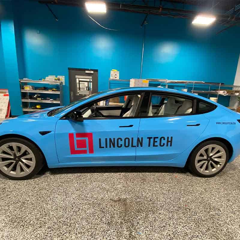 Branded car wrap with Lincoln Tech name and logo by Strategic Factory.