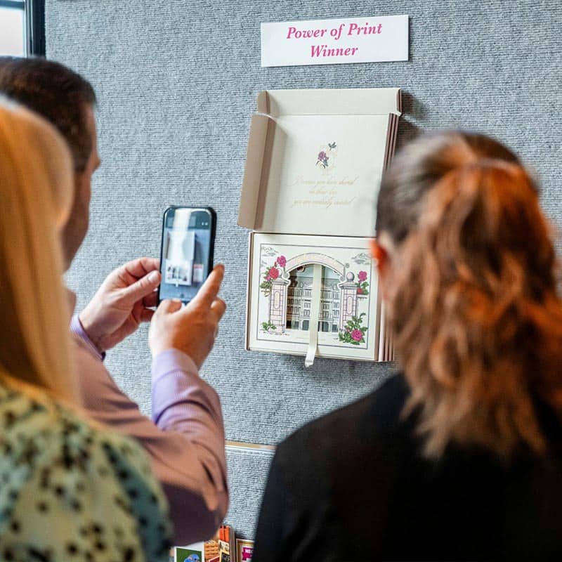 woman taking picture of displayed packaging award winner